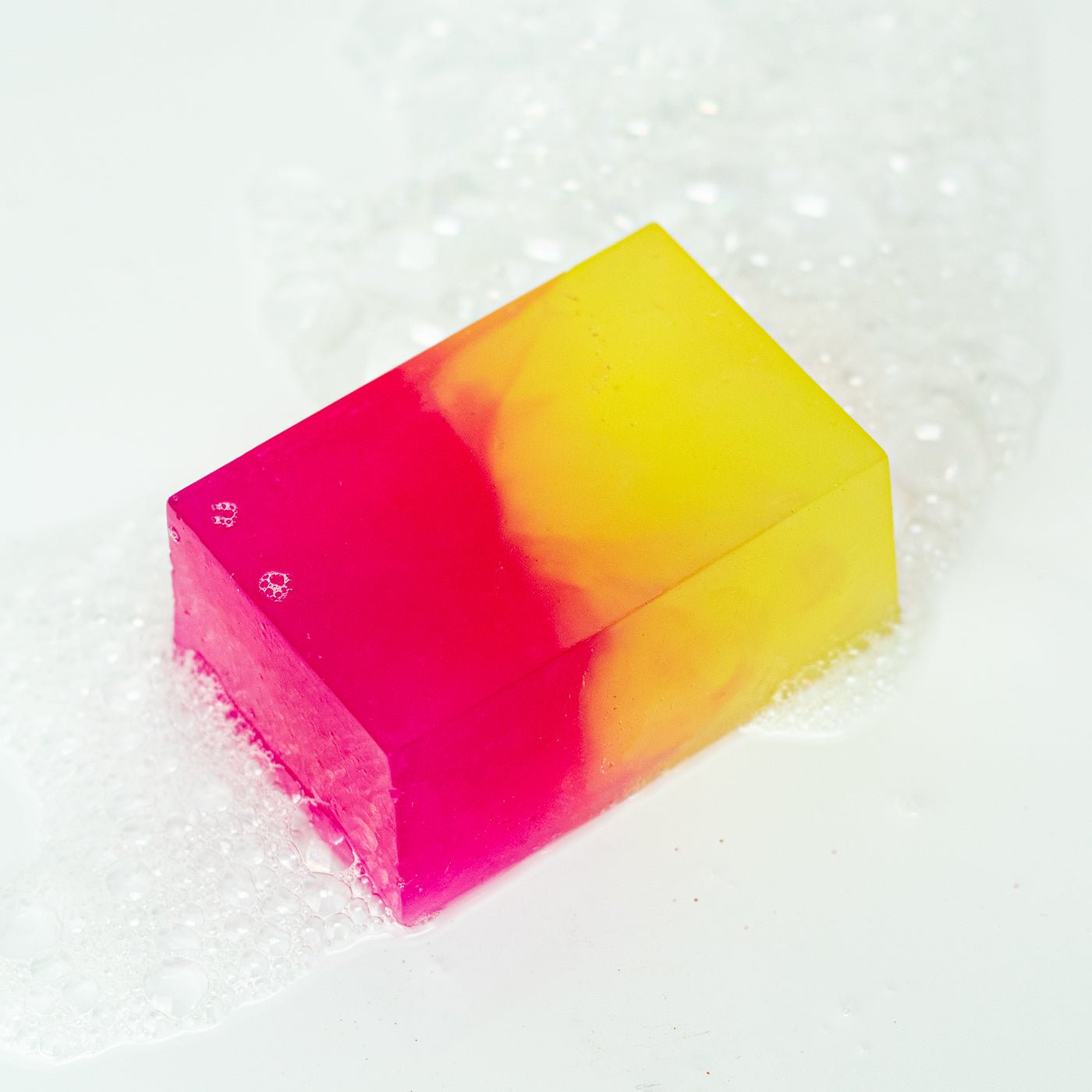 Colourful soap bar with a pink and yellow gradient on a white background