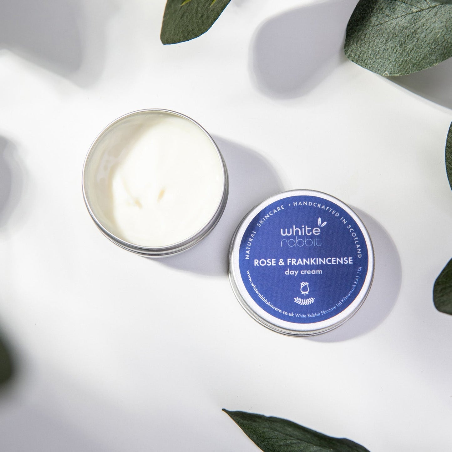 White Rabbit Rose & Frankincense Revitalising Day Cream 30ml on a white background with green leaves.