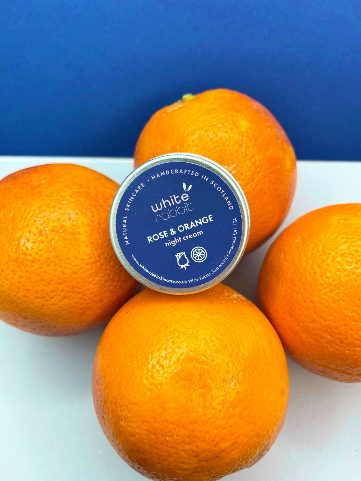 White Rabbit Rose & Orange night cream with oranges on a blue background