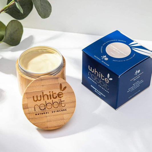 Jar of cream with wooden lid and 'White Rabbit Natural Skincare' packaging on a white background