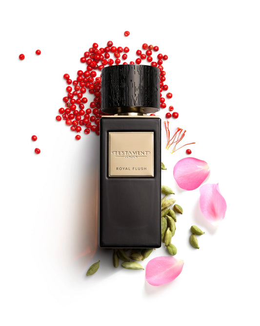 Perfume bottle labeled 'Testament' with red berries and pink petals on a white background