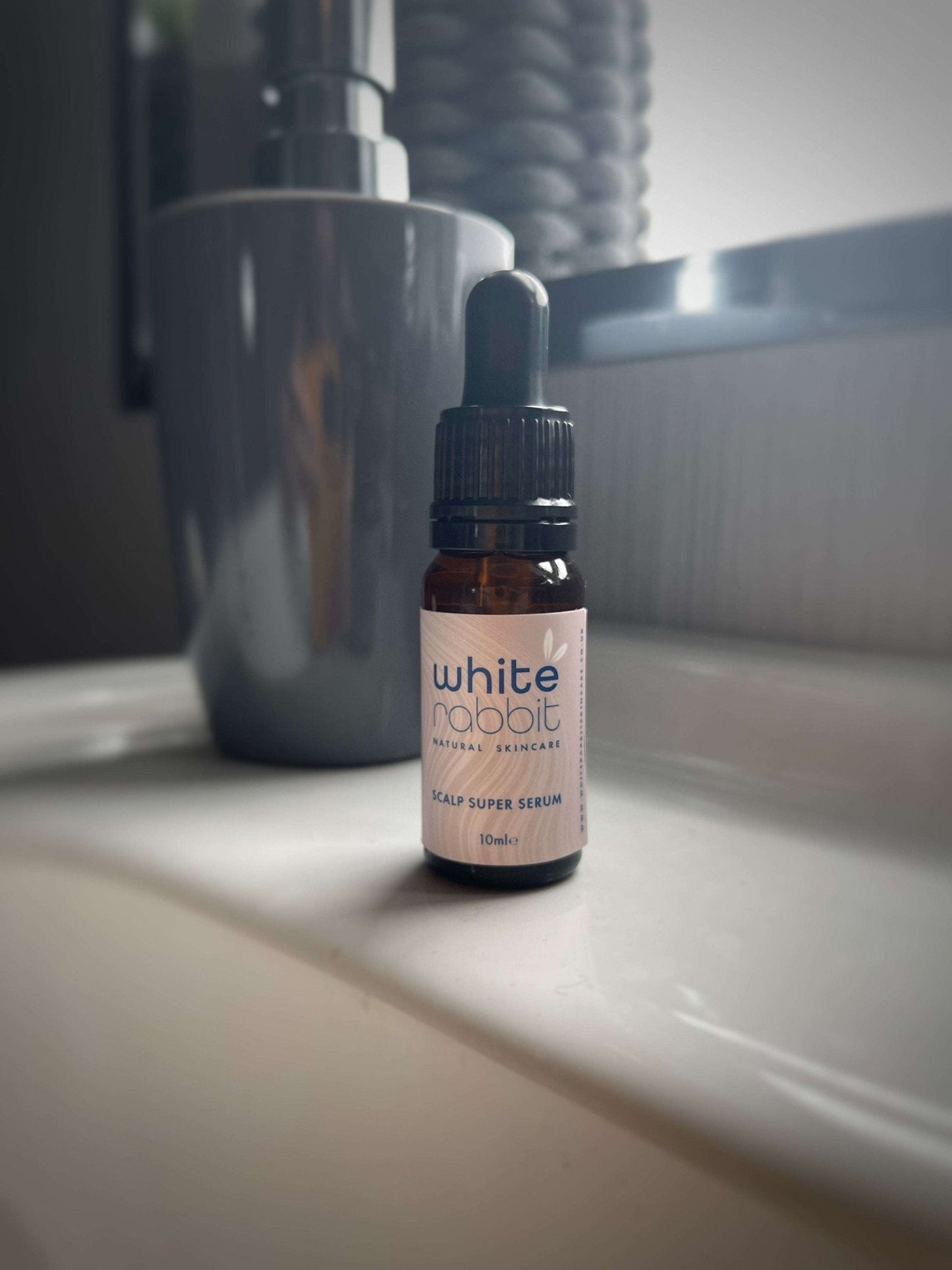 Bottle of 'White Rabbit' scalp serum on a bathroom counter