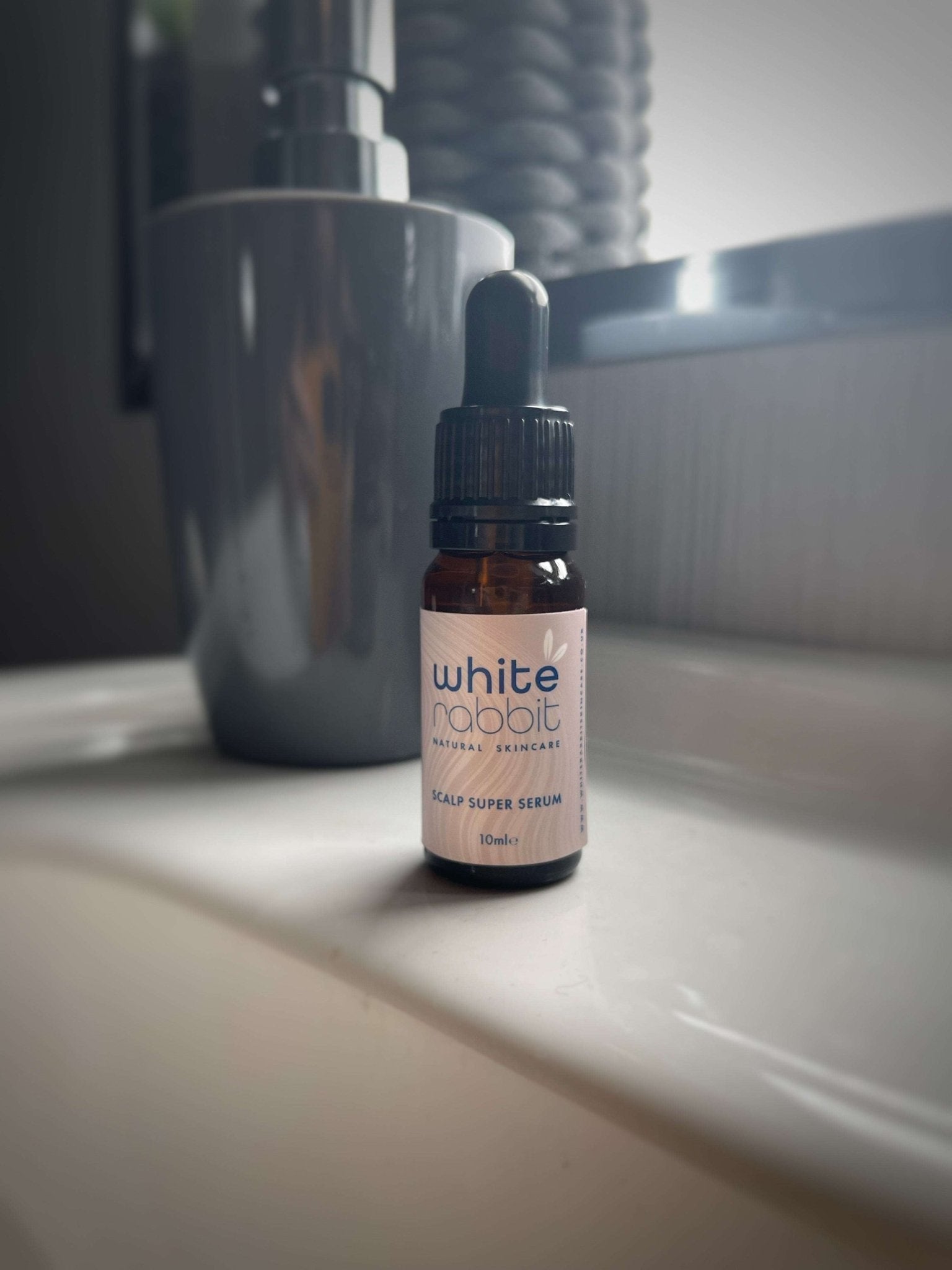 Bottle of 'White Rabbit' scalp serum on a bathroom counter