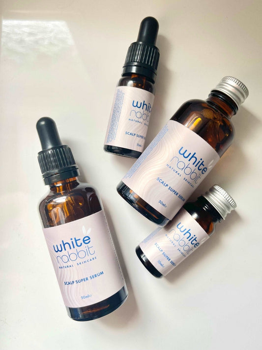 Four bottles of 'White Rabbit' scalp serum on a white background
