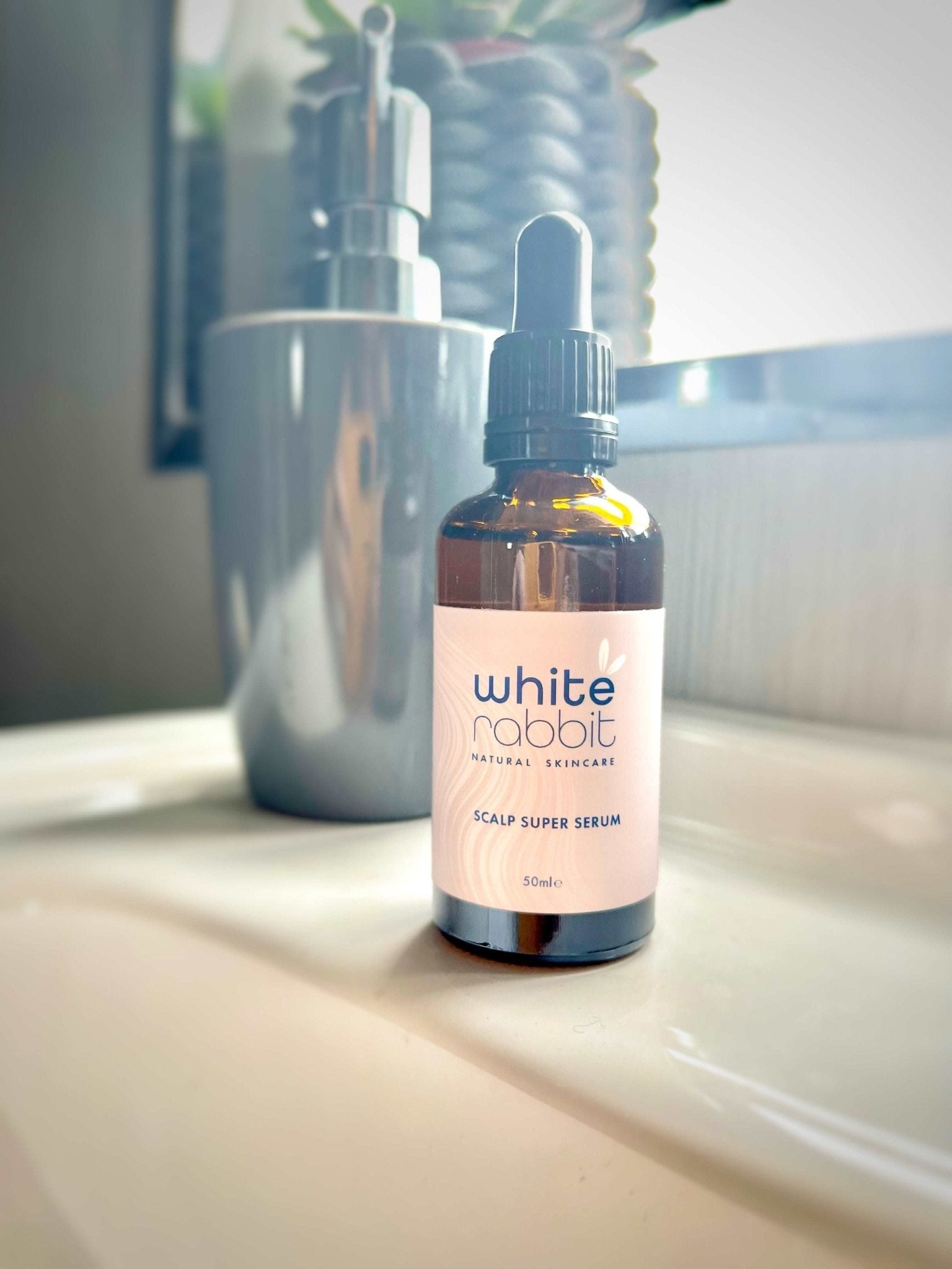 Bottle of White Rabbit Scalp Super Serum on a bathroom counter