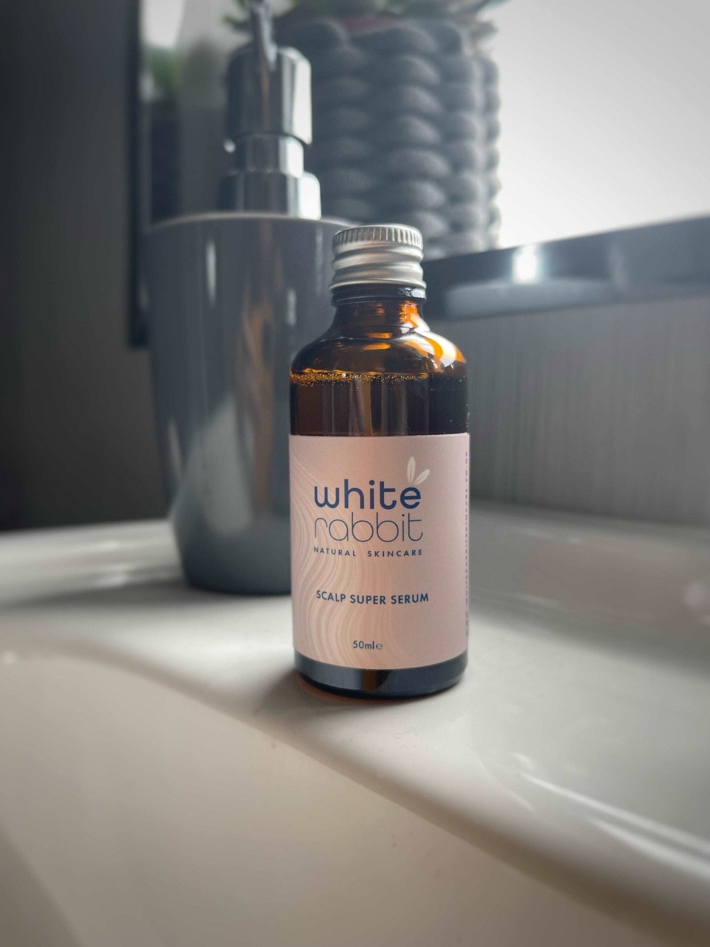 Bottle of 'White Rabbit' scalp super serum on a bathroom counter.