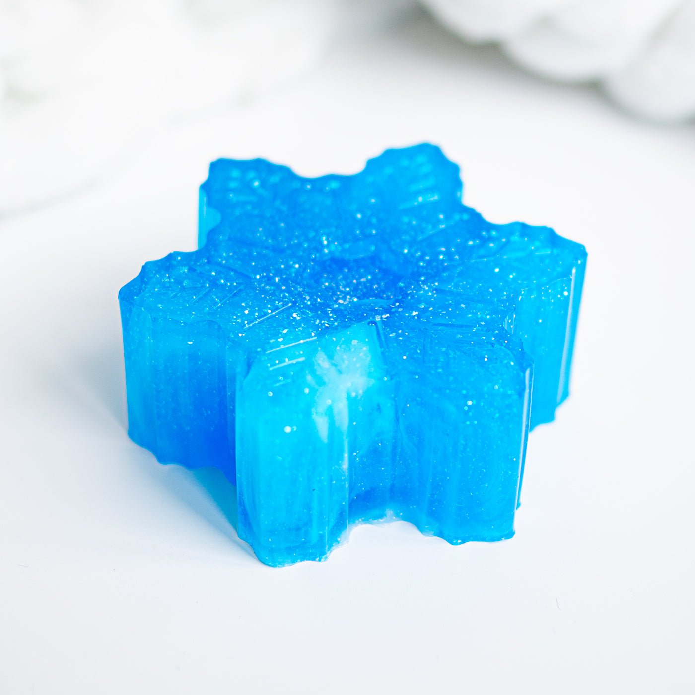 Blue star-shaped soap with a glistening surface on a white background
