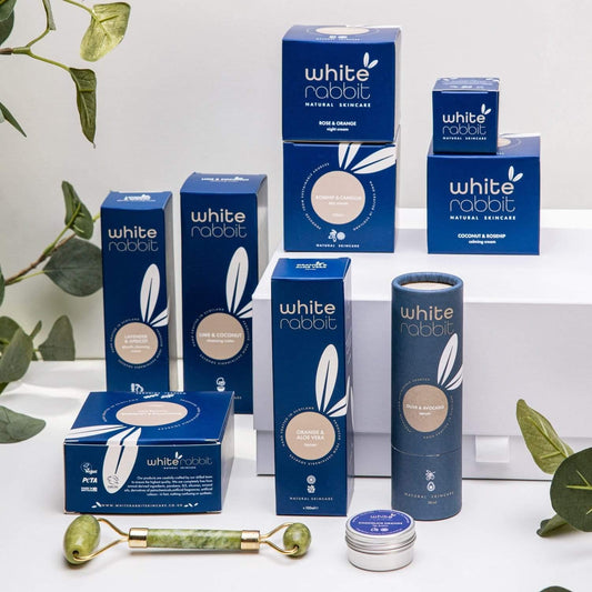 White Rabbit skincare products on a white background with green leaves.
